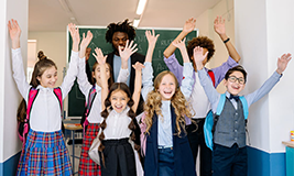 happy school students standing with their professor