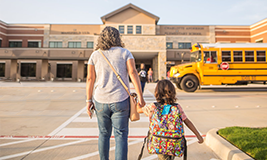 parent walking the child to school bus